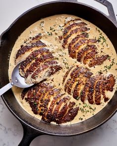 a skillet filled with some meat covered in gravy