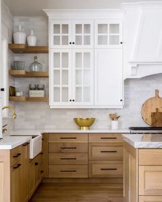 a kitchen with wooden cabinets and white counter tops, gold accents on the backsplash