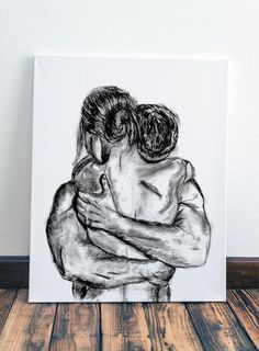 a black and white drawing of two people hugging each other on a wooden floor with a wall in the background