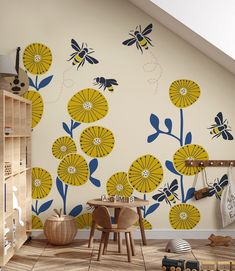 a child's room with yellow and blue flowers on the wall, wooden table and toy cars