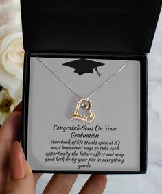 someone is holding up a graduation necklace in their hand and it says congratulations to you