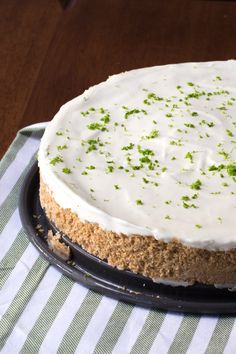 a cake with white frosting and green sprinkles sitting on a plate