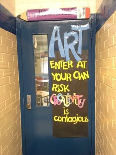 a door with some writing on it in front of a brick wall that says art