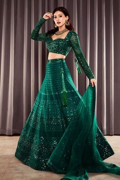 Emerald green lehenga in net base with geometric motif sequin embroidery. Paired with sweetheart neck, long sleeved choli and dupatta.
Components:3
Pattern:Embroidered
Type of Work:Sequins
Neckline:Sweetheart
Sleeve Length:Long
Fabric:Net
Color:Green
Other Details:
Back cut-out choli
Tassel edged dupatta
Occasion:Wedding, Bride - Aza Fashions Anarkali Green Lehenga With Sequins, Party Wear Green Lehenga With Resham Embroidery, Green Resham Embroidery Lehenga For Party Wear, Green Sequined Choli For Reception, Designer Green Sequined Lehenga, Festive Green Lehenga With Sequins, Festive Green Sequined Lehenga, Fitted Green Sequined Set, Green Anarkali Style Choli With Sequins