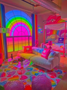 a living room filled with lots of furniture and rainbow colored curtains on the window sill