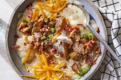 a bowl filled with mashed potatoes topped with bacon and cheese