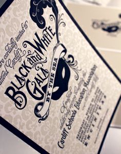 a black and white wedding card with a mask on it