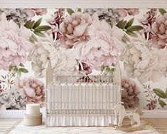 a baby crib in front of a floral wallpaper