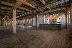 an empty room with wooden floors and exposed ceilings