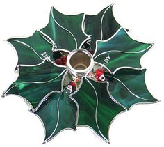 a green glass christmas decoration with holly leaves