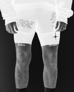 black and white photograph of man wearing shorts with writing on them