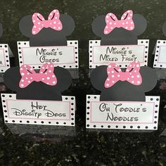 some minnie mouse signs with pink bows on them