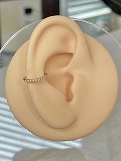 a close up of a fake ear with a ring on it's end, sitting on a table