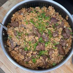 a pot filled with rice and meat on top of a wooden table