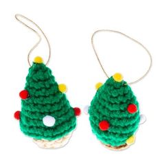 two crocheted christmas ornaments are hanging from chains on a white surface, one is green and the other is red