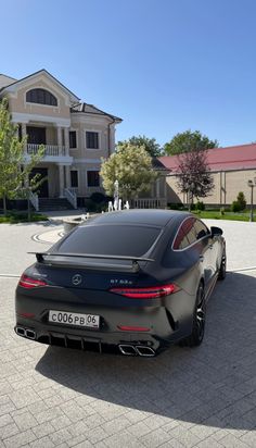 a black car parked in front of a large house