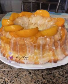 a cake covered in icing and sliced peaches