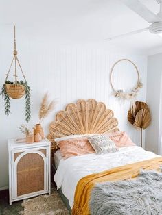 a bedroom with white walls and wood floors, an orange blanket on top of the bed