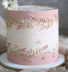 a pink and white cake with flowers on it