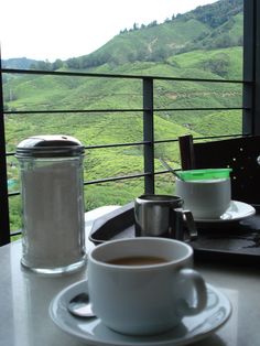 a cup of coffee sitting on top of a saucer next to a canister