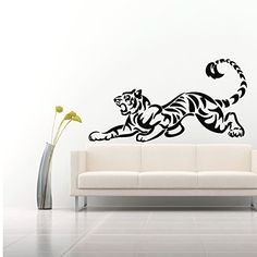 a white couch sitting next to a wall with a black and white tiger decal on it