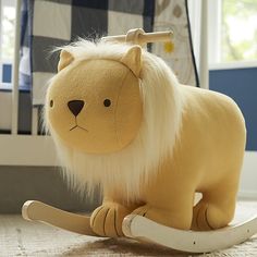 a stuffed lion is sitting on a rocking toy