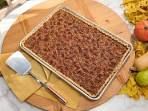 a waffle cake sitting on top of a wooden cutting board next to other food