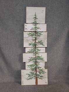 a christmas tree made out of wooden planks on top of a gray cloth background