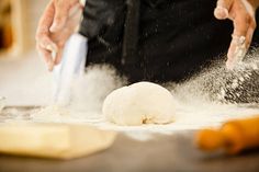 a person is kneading dough on a table