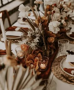 the table is set with flowers and candles