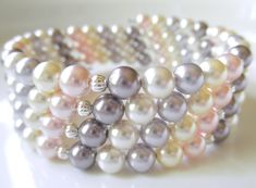 Pretty Pastel Swarovski Pearl Memory Wire Bracelet  Composed of premium Swarovski crystal pearls in rosaline, mauve, lavender, cream and white and accented with silver melons. Perfect with a pretty white sundress or for a summer bride.  It wraps around the wrist 4 times and will retain it's slinky shape. Very easy to put on and remove by simply wrapping the wire around your wrist. One size fits an average wrist The inner diameter is 2.5 inches and the width measures just under 1 inch. The bracelet ends are looped. READY TO SHIP NOTE: If you would prefer this bracelet using different Swarovski pearl colors, simply send me a custom order request in a convo and together we can work on the perfect bracelet for you! This piece arrives gift- boxed - perfect for gifting or personal storage for yo Bridal Party Beach, Honey Jewelry, Beach Wedding Jewelry, Memory Wire Wrap Bracelets, Wire Bracelets, Bracelets Patterns, Coil Bracelet, Easy Jewelry, Bracelet Pearl