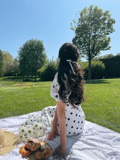 a woman sitting on top of a white blanket