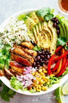 a salad with grilled chicken, avocado, black beans, corn, tomatoes and cilantro