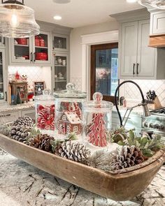 a tray filled with candy canes and pine cones on top of a kitchen counter