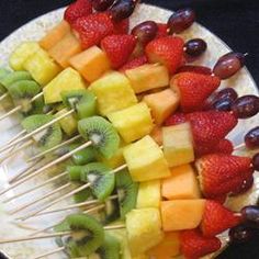 fruit skewers are arranged on a white plate