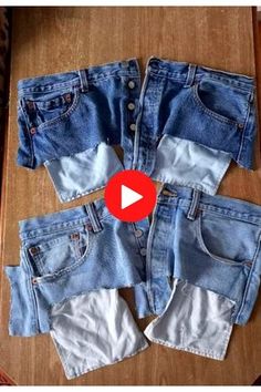 four pairs of jean shorts sitting on top of a wooden table