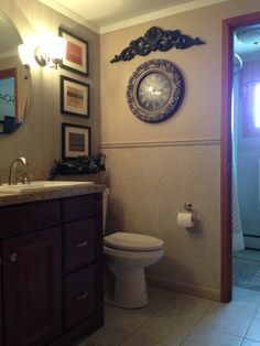 a bathroom with a toilet, sink and mirror in it's corner next to a doorway