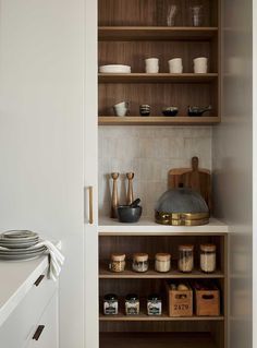 the shelves in this kitchen are filled with plates and bowls, along with other items