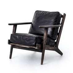 a black leather chair sitting on top of a white floor next to a wooden frame