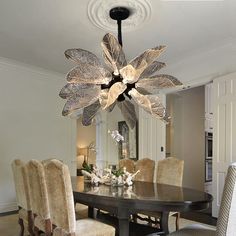 a dining room table with chairs and a chandelier hanging from it's ceiling