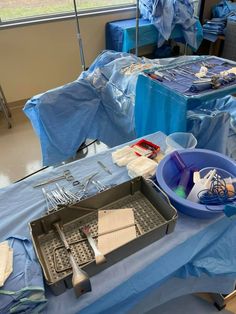 the table is covered with blue plastic and other medical supplies, including utensils