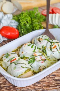 a casserole dish filled with meat covered in white sauce and garnished with herbs