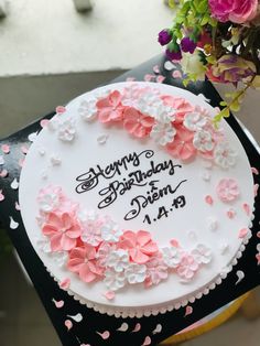 a birthday cake with pink and white flowers on it