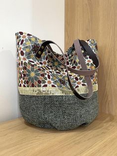 a purse sitting on top of a wooden table next to a wall with a door in the background