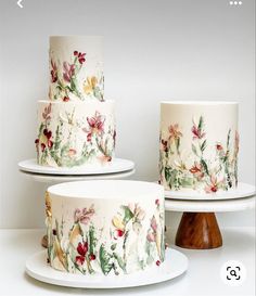 three tiered cakes with flowers painted on them