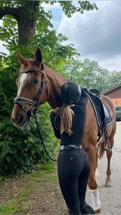 a woman standing next to a brown horse