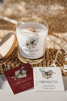 a candle and some cards sitting on top of a table next to each other with the words christmas eve printed on them