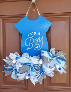 a door hanger that says it's a boy with blue and white bows