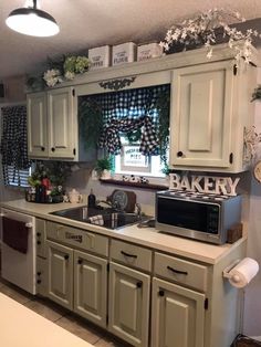 a kitchen with green cabinets and white appliances