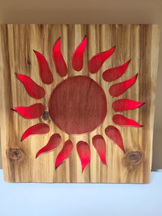 a wooden box with red flowers on it and two holes in the middle that have been cut out to look like sunbursts